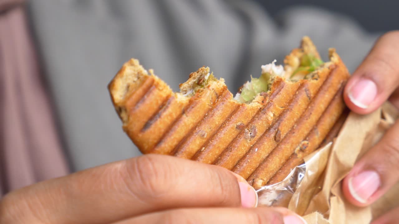 primer plano de una persona comiendo un delicioso sándwich