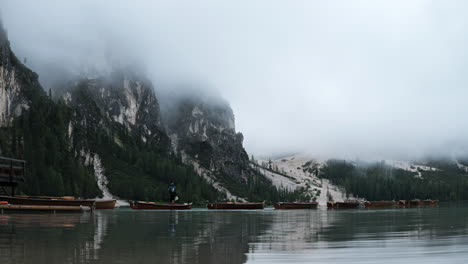 people preparing tourism row boats on braies lake time lapse under misty dolomites mountain valley