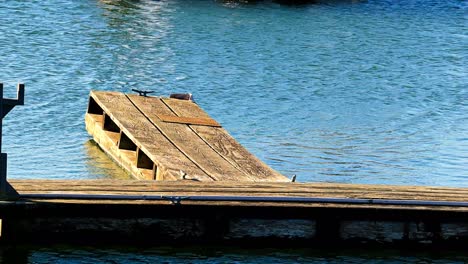 Altes-Hölzernes-Bootsdock-Im-Hafen-Ohne-Boot-Im-Sonnigen-Blauen-Wasser