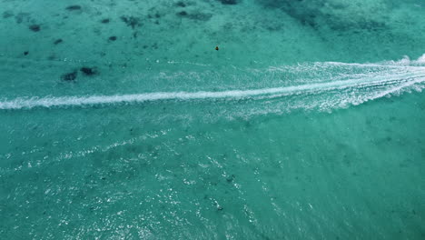 Static-backwards-aerial-of-speedboat-driving-on-ocean,cinematic