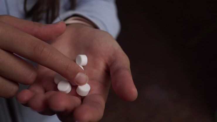 Person holding pills in their hand