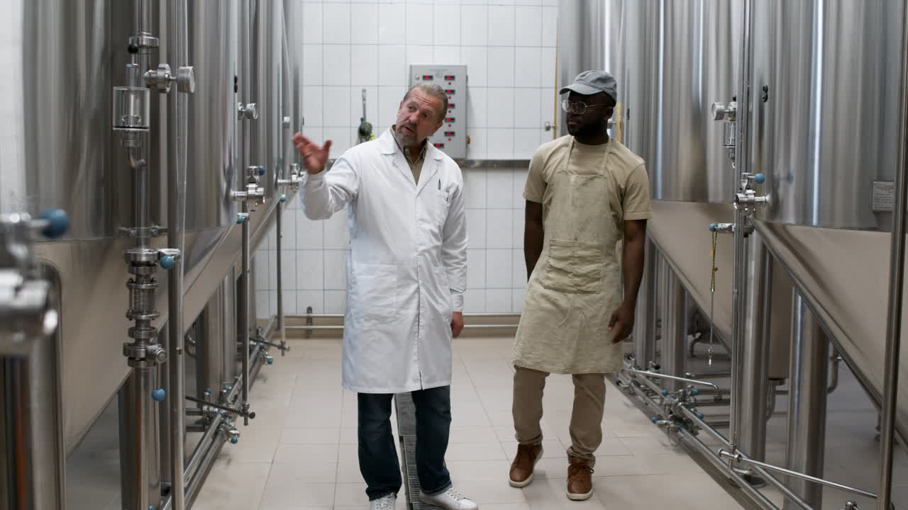 두 노동자가 공장에서 이야기를 나누고 있다