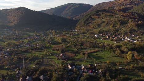 Orbit-shot-over-a-secluded-village-at-sunset,-autumn