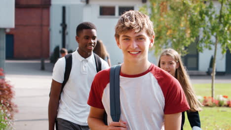 portrait of male teenage student walking around college campus