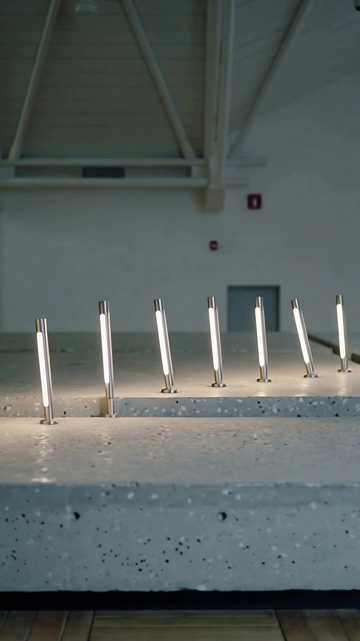 Vertical video: Panning camera revealing row of tubular LED lights on stepped bench