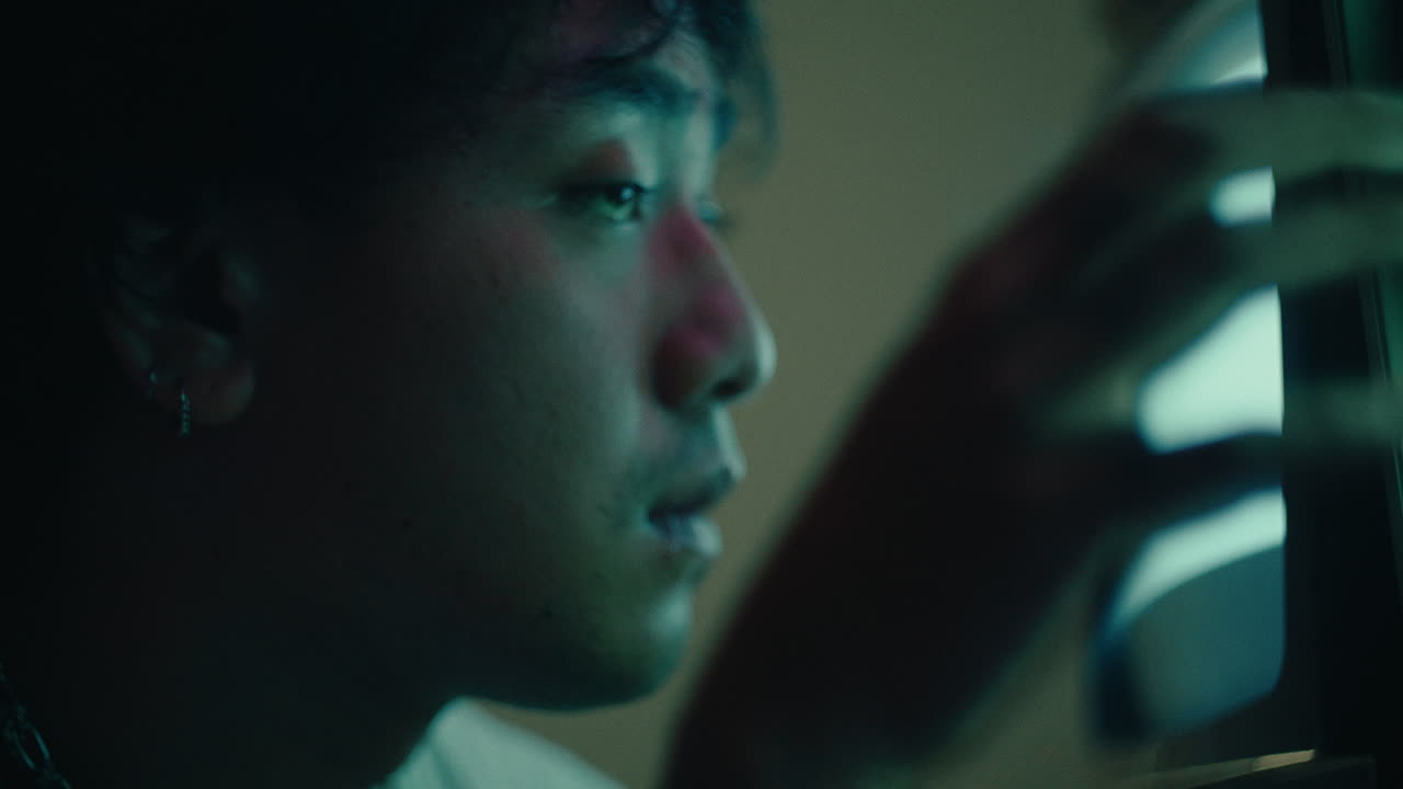 close up of alternative young male staring at old art tv monitor alone in a room