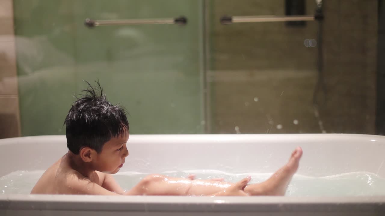 Asian boy take a bath with rubbing his body on the bathtub
