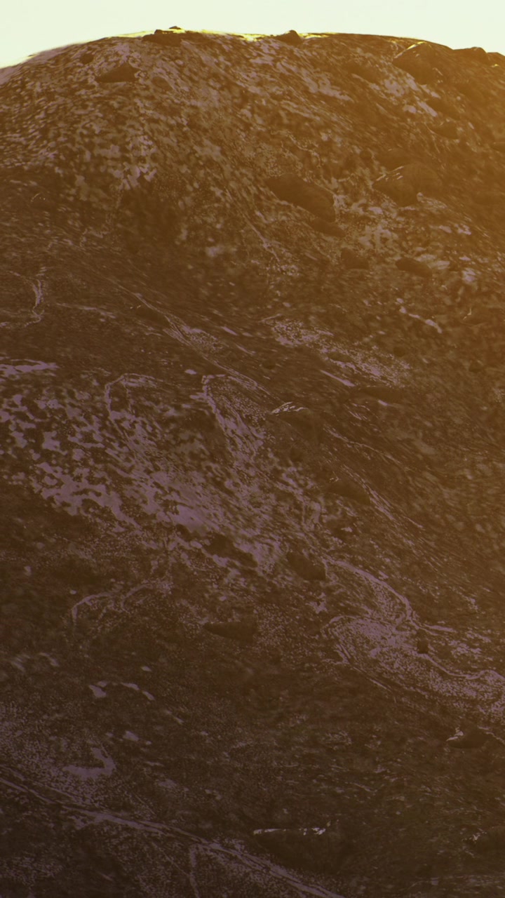 Tramonto su un terreno roccioso con texture sulla superficie di una montagna.