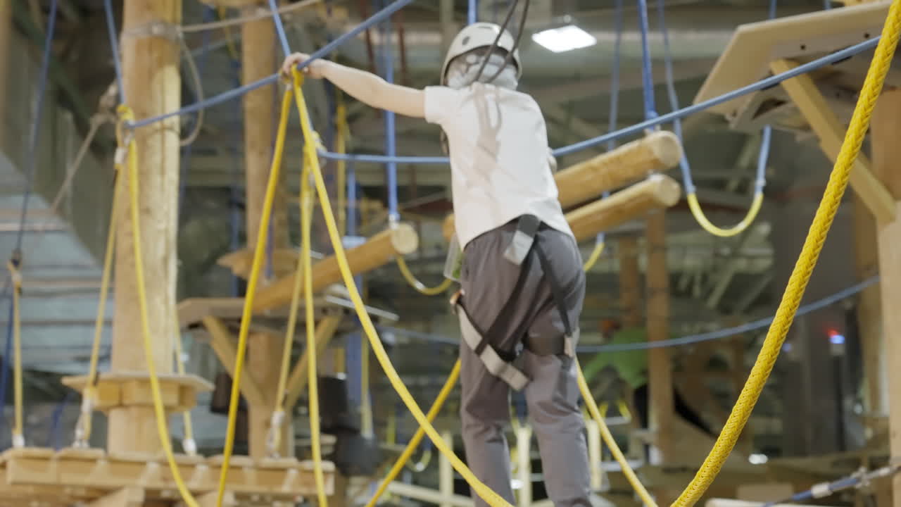 Person navigating an indoor adventure rope course