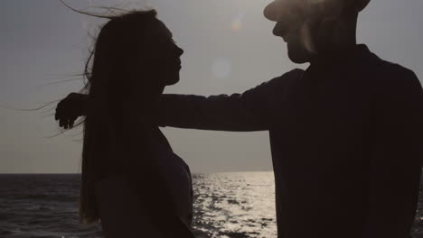 happy young couple hugging and kissing at seaside