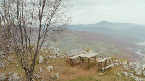 Alte-Holzbank-Mit-Blick-Auf-Das-Bergtal,-Malerische-Landschaftsluftaufnahme