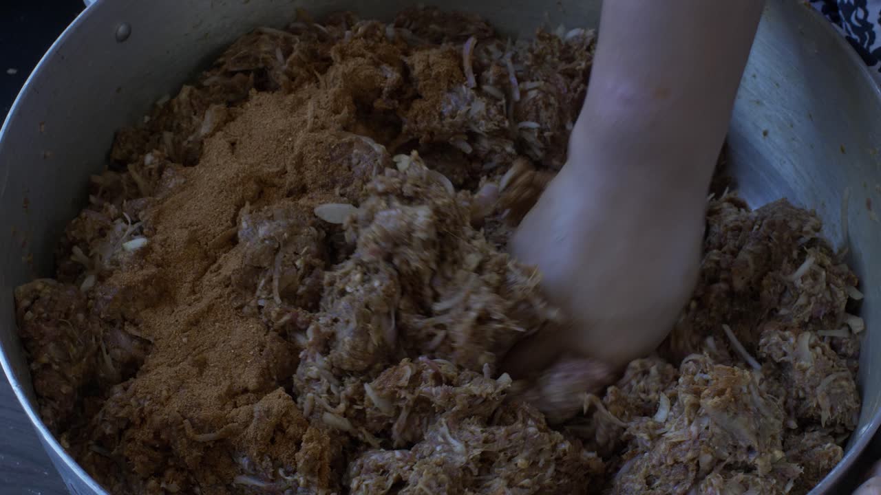 다진 고기에 카레 가루와 양파를 섞은 여성 손