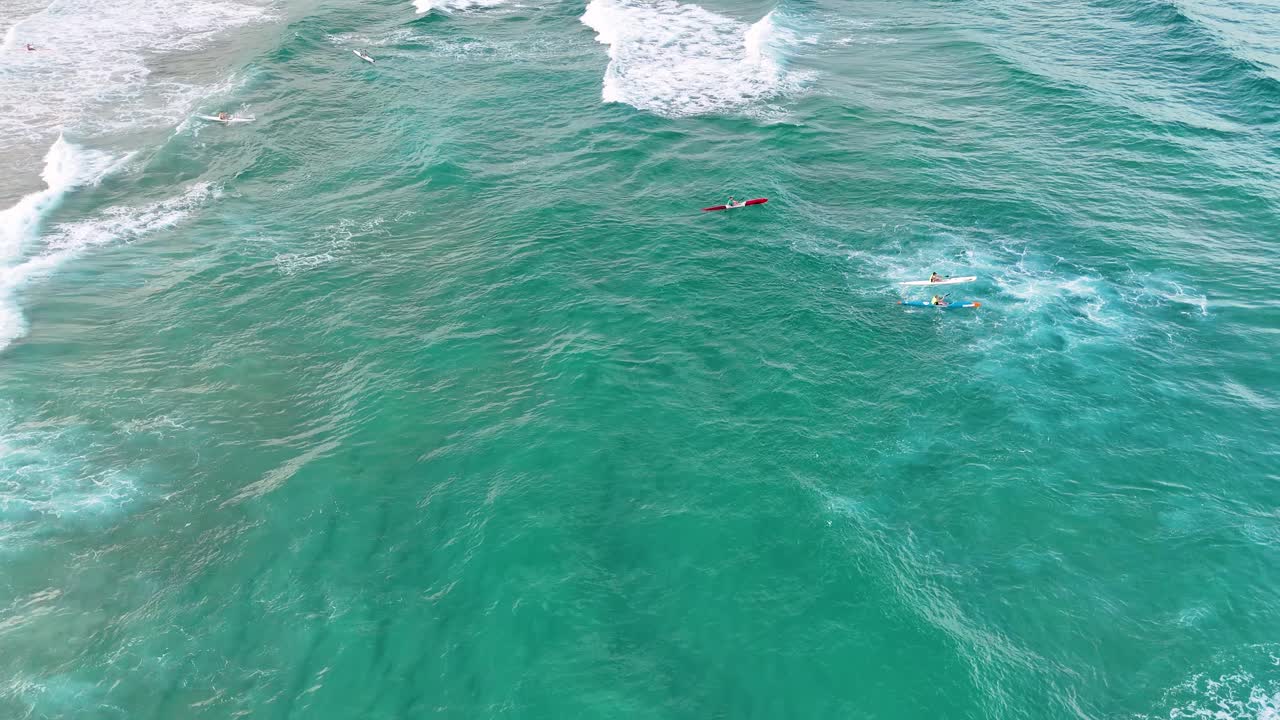 los socorristas rescatan a los surfistas en las turbulentas olas del océano