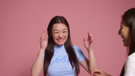 Group-Of-Young-Friends-In-Front-Of-Pink-Studio-Background-Posing-For-Photo-Booth-Style-Portraits-1