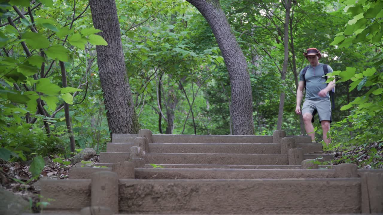 男徒步旅行者走下楼梯低角度视角,在山上徒步旅行的概念