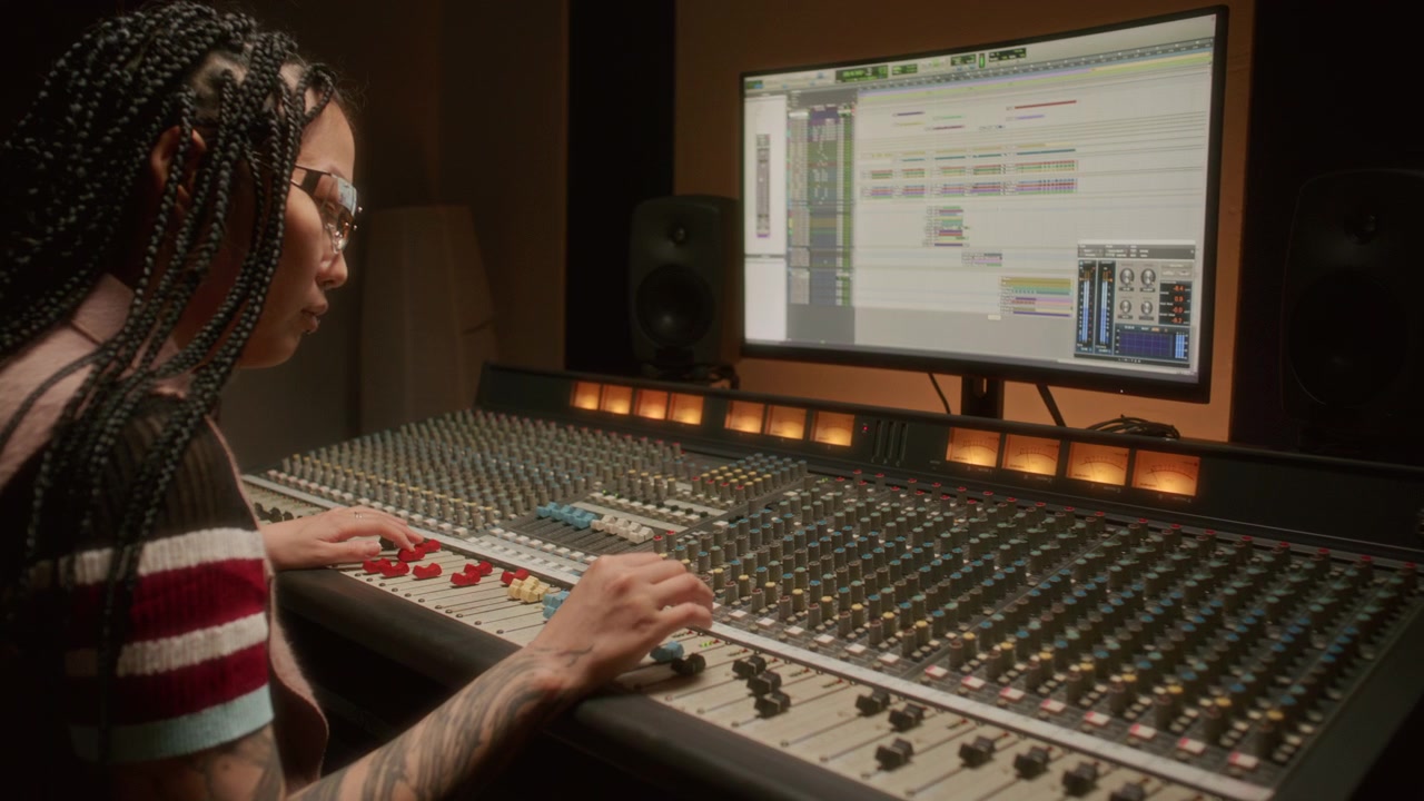 Asian Female Music Producer Editing Audio Tracks in Recording Studio