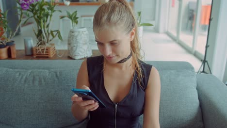 woman using smartphone on a couch in a living room