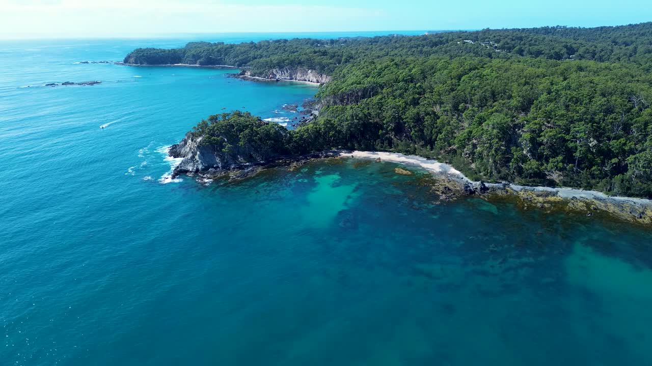Paisagem aérea de drone da enseada rochosa à beira-mar, praia arenosa, promontório com arbustos e árvores e recife oceânico transparente ao longo da costa natural de Batemans Bay, na Austrália, com trilhas para caminhadas, viagens, turismo e férias