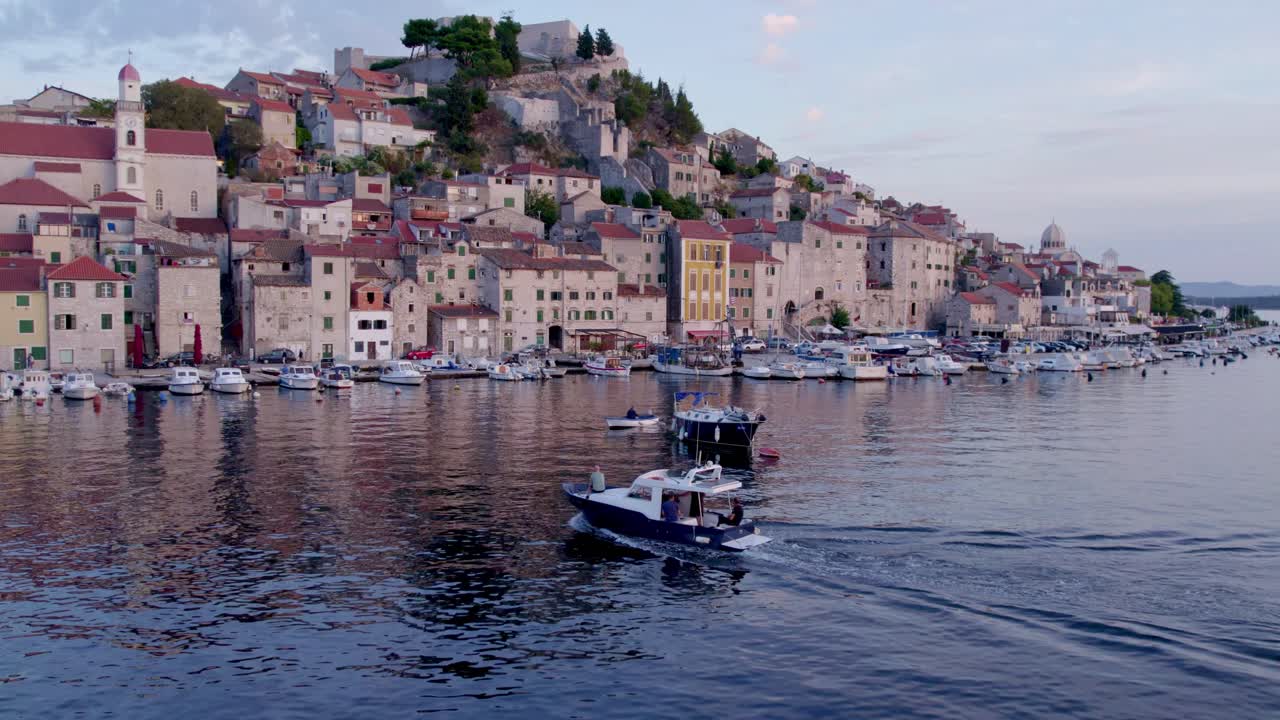 vista de avión no tripulado de la ciudad de sibenik en croacia durante la puesta del sol con una lancha a motor, aérea