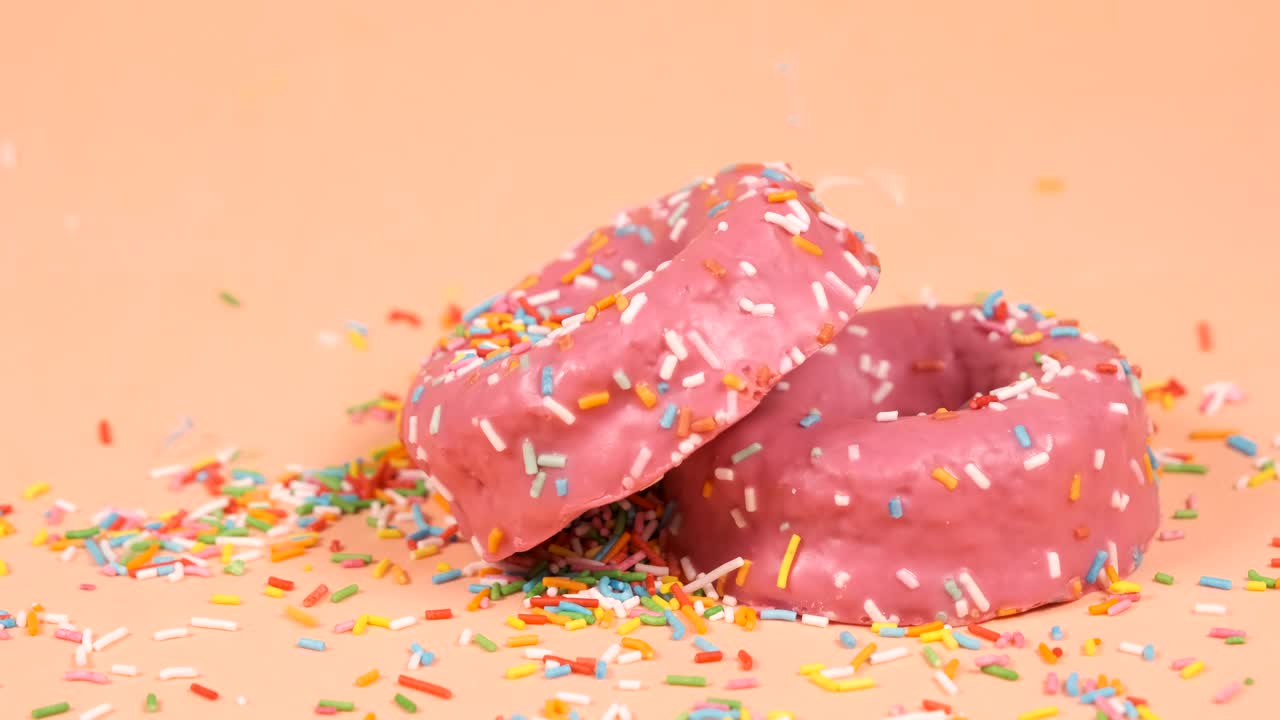 las virutas de colores que caen sobre dos rosquillas de fresa