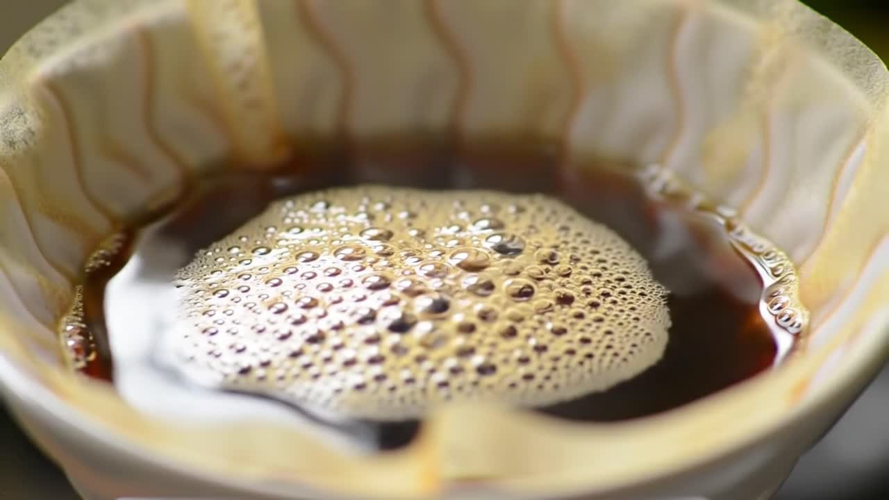 Steam and bubbles rise as rich coffee brews through a filter, filling the kitchen with a delightful aroma. A serene morning moment of relaxation and enjoyment.