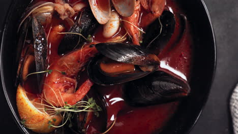 overhead flat lay spoon is falling into a bowl with seafood soup. 420 fps slow motion shot with high speed camera