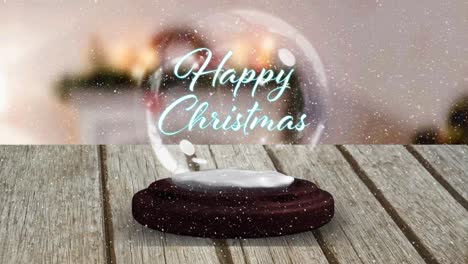 Animation-of-happy-christmas-text-in-snow-globe-on-wooden-table