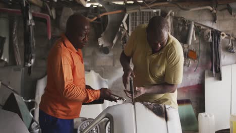 hombres africanos reparando un coche