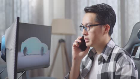 man talking on phone while working on car design