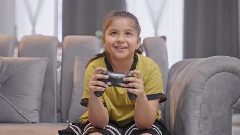 happy indian gamer kid playing video games using controller