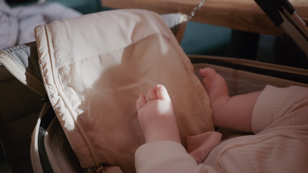 Bambino a riposo in un passeggino, vicino a un tavolo, in un ambiente al chiuso.