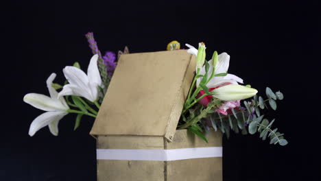 Floral-arrangement-spinning-inside-golden-box-lily-rose-daisy-gerbera