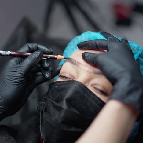 cosmetologist draws eyebrows. the cosmetologist prepares to make eyebrow tattoo