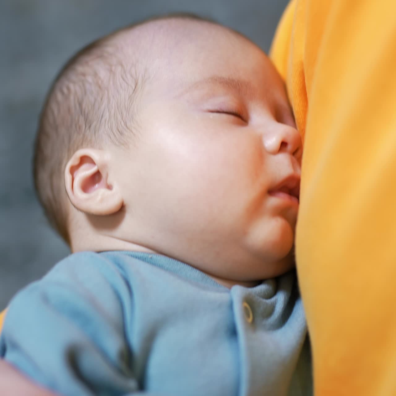 Newborn baby sleeping peacefully in daddy's hands. Adorable sleeping child in a blue suit. Close up