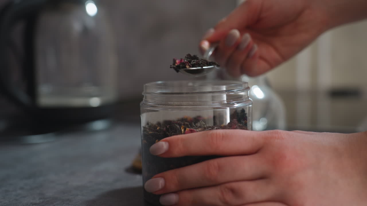 Glass Teapot With Loose Tea Leaves Settling On Base, Warm Kitchen Light, Shallow Depth, Slow Infusion, Steam Haze, Reflective Surface, Close Macro On Leaf Texture And Amber Tint, Cozy Meditative Mood