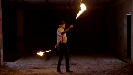 artista masculino realizando un espectáculo de fuego en la oscuridad en cámara lenta.