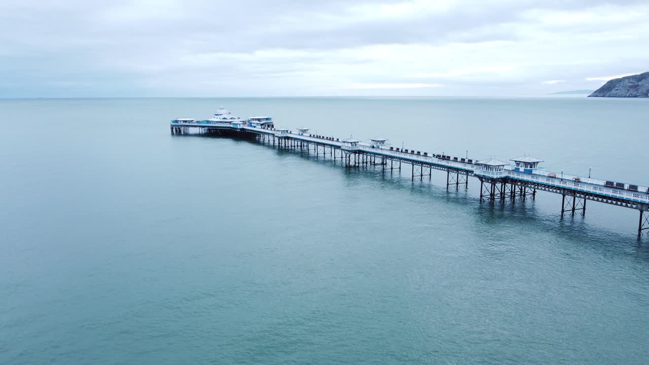 llandudno muelle histórico paseo marítimo de madera victoriano punto de referencia junto al mar vista aérea lento descender a la derecha