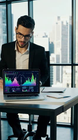 businessman analyzing financial data on laptop in office