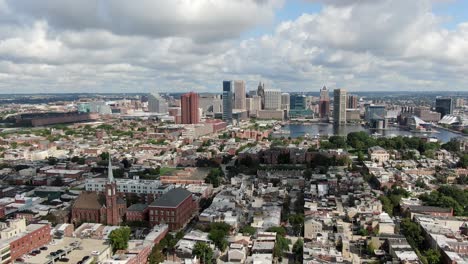 Wide-aerial-descending,-downtown-Baltimore-City-and-Inner-Harbor,-homes-and-residential-communities-in-foreground,-Federal-Hill,-Riverside,-Sharp-Leadenhall