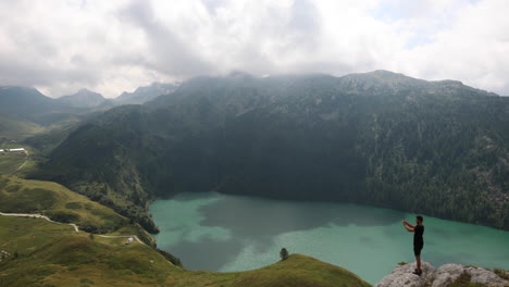 Backpacker-enjoying-the-view-and-record-a-video-of-the-famous-Lake-Ritom-in-Switzerland