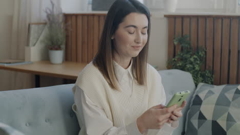 woman texting on a couch