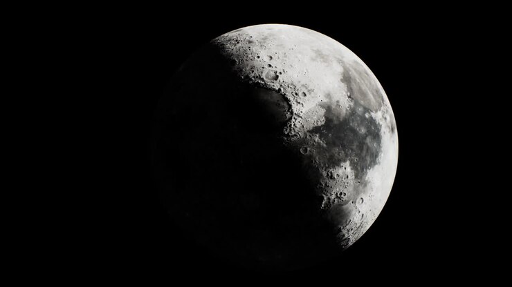 Lua cheia iluminada contra um céu noturno escuro com textura detalhada.