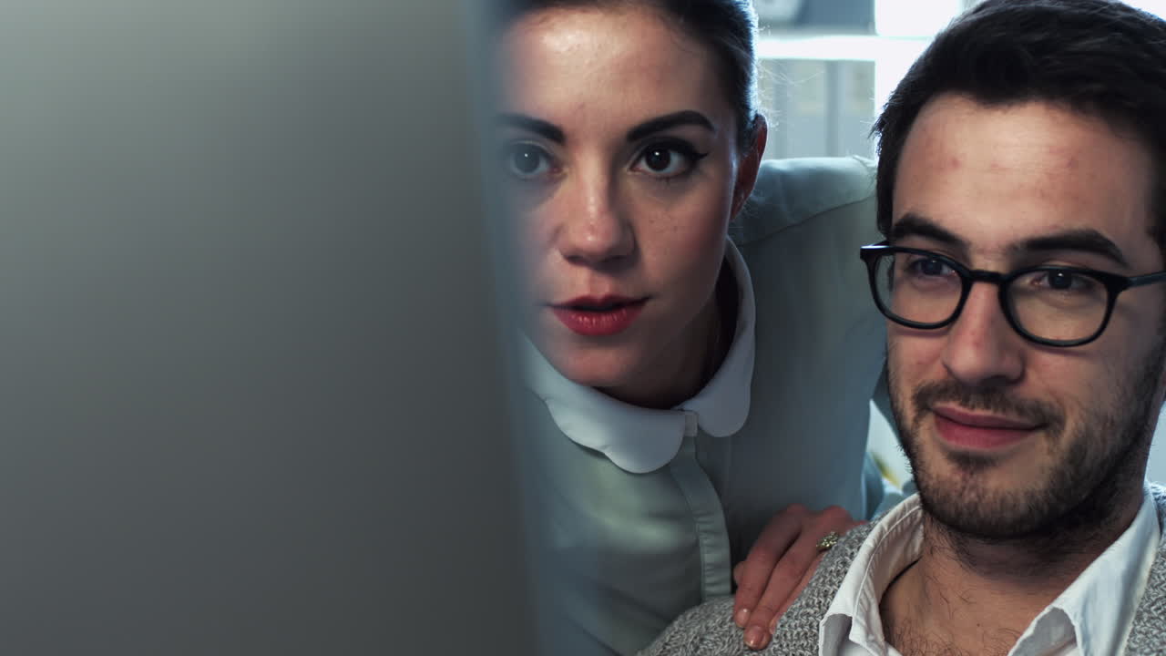 pareja joven atractiva trabajando en la computadora tarde en la noche en casa