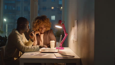 african american man and woman working late in office
