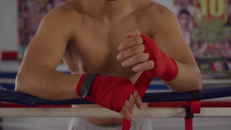 hombre caucásico envolviendo las manos en el ring de boxeo