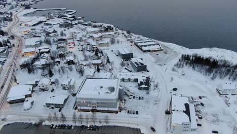 vista de avión no tripulado en tromsø de finnes, una pequeña ciudad llena de nieve y montañas en el horizonte en noruega