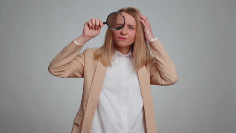 investigator researcher woman with magnifying glass near face looking into camera with big zoom eye
