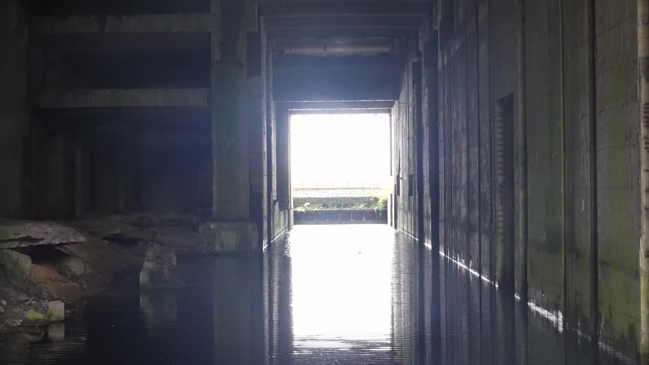 Interior view of the WW2 Bunker Valentin submarine exit channel in Bremen, showing massive concrete walls, flooded floor and historic wartime structure