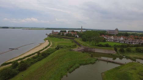 Aerial-shot-of-the-historical-town-of-Veere,-with-an-old-windmill-in-frame