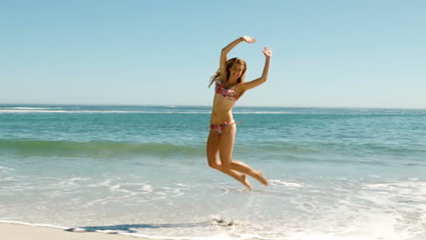 Attraktive-Junge-Frau-Springt-Am-Strand